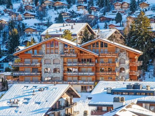 een lodge in de sneeuw met besneeuwde daken bij Apartment Ferme de Sandra E0 by Interhome in Nendaz