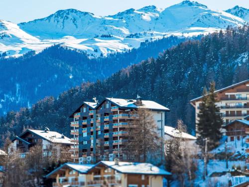 a resort with snow covered mountains in the background at Apartment Haut de Cry 16 by Interhome in Nendaz