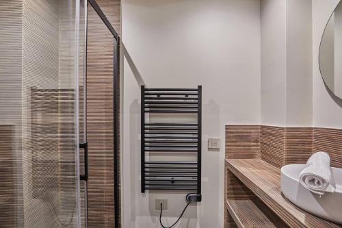 une salle de bain avec un lavabo et une douche en verre dans l'établissement Cozy apartment Montmartre Moulin rouge, à Paris