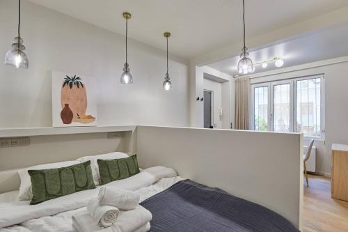 - une chambre avec un lit doté d'oreillers verts et blancs dans l'établissement Cozy apartment Montmartre Moulin rouge, à Paris
