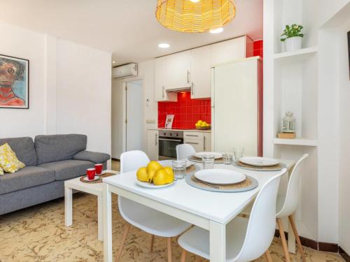 una cucina e un soggiorno con tavolo e sedie bianchi di Apartment Garbinada by Interhome a Tossa de Mar