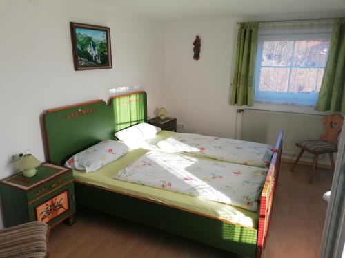 a bedroom with a green bed in a room at Ferienwohnung Allgäuflair in Rieden am Forggensee