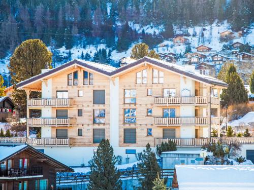 an apartment building in the mountains with snow on the ground at Apartment Moulin du Raé A2 by Interhome in Nendaz