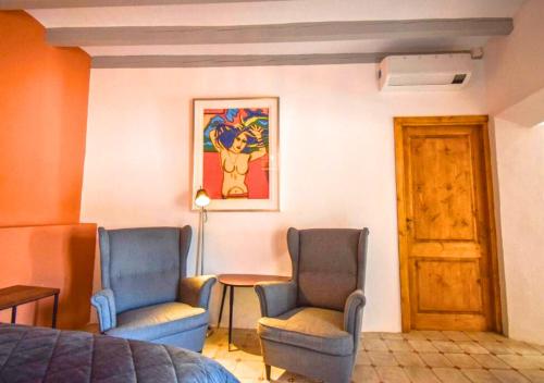 a room with two chairs and a table and a bed at Solleric Petit Hotel in Sóller
