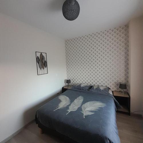 - une chambre avec un lit doté d'une couette bleue et de 2 oreillers dans l'établissement La Grange aux Abeilles 1, à Saint-Senier-sous-Avranches