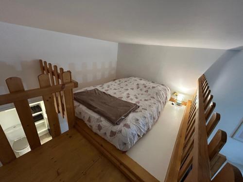 une petite chambre avec un lit dans une pièce dans l'établissement Studio spacieux, centre ville, à Le Pont-de-Beauvoisin