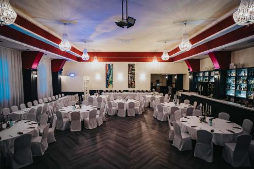 a banquet hall with white tables and white chairs at Hotel Restaurant Kreuz Spaichingen in Spaichingen