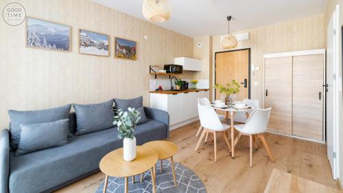 a living room with a blue couch and a table at Apartamenty Good Time - Belle View - Centrum in Szklarska Poręba