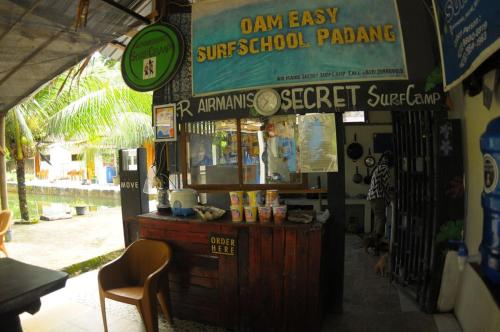 a restaurant with a counter and a sign on the wall at Air Manis Secret Surfcamp in Taluk Batung
