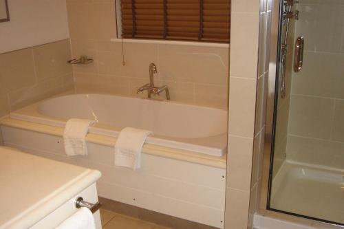 a bathroom with a bath tub and a shower at 2br-sleeps4-pool-freeparking-trenythonestate in Par