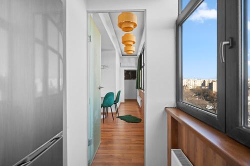 a hallway with a window and a green chair at Bucharest Mall View in Bucharest