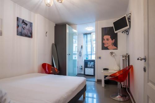 アントワープにあるHotel Urban Dreamsのベッドルーム1室(ベッド1台、赤い椅子2脚付)
