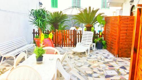 a patio with chairs and tables and a fence at Casa Filomena in Ischia