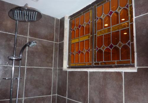 La salle de bains est pourvue d'une douche et d'une fenêtre. dans l'établissement Les Remparts, à Avignon