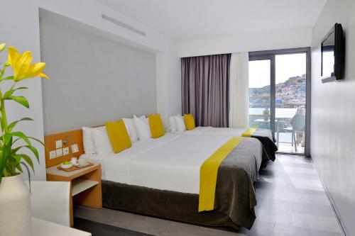 a hotel room with a large bed and a window at Airotel Galaxy in Kavala