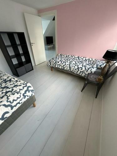 a room with two beds and a wooden floor at Cozy home in quiet neighborhood in Ängelholm