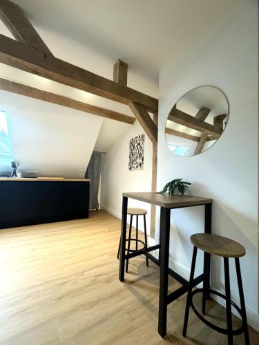 une chambre avec une table, deux tabourets et un miroir dans l'établissement Le Grenier de la Grappe 2, à Lille