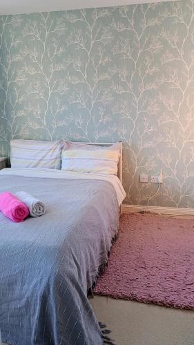 a bedroom with a bed with a pink rug at BIENVENUE in NEWHAVEN Luxury superking OR standard OR budget rooms in Newhaven