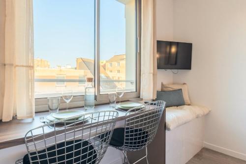 une pièce avec une table, des chaises et une fenêtre dans l'établissement Studio proche écoles, commerces et centre-ville, à Lille