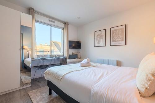 une chambre avec un grand lit et une grande fenêtre dans l'établissement Studio proche écoles, commerces et centre-ville, à Lille