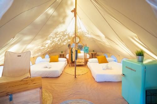 a tent with two beds in a room at Kampaoh El Rocío in El Rocío