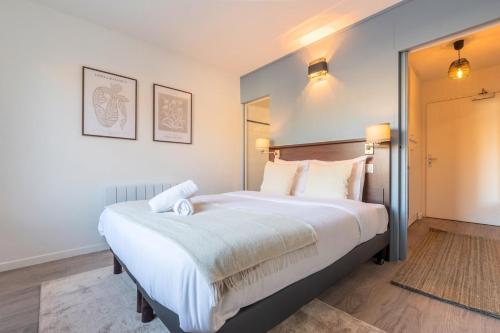 une chambre avec un grand lit avec des draps blancs dans l'établissement Studio proche écoles, commerces et centre-ville, à Lille