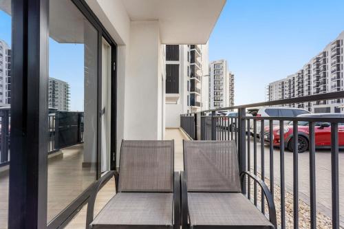 two chairs sitting on the balcony of a building at Prime Location 2BR Apartment with Pool & Dining Nearby in Abu Dhabi