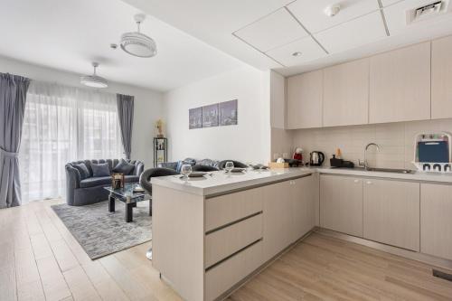 an open kitchen and living room with a couch at Prime Location 2BR Apartment with Pool & Dining Nearby in Abu Dhabi