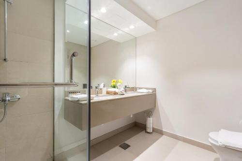 a bathroom with a sink and a shower at Prime Location 2BR Apartment with Pool & Dining Nearby in Abu Dhabi