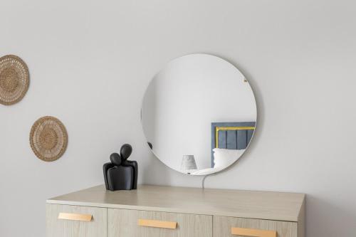 a mirror on top of a dresser in a room at Prime Location 2BR Apartment with Pool & Dining Nearby in Abu Dhabi