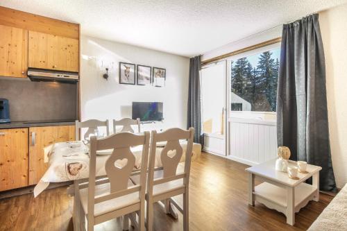 une cuisine et une salle à manger avec une table et des chaises dans l'établissement L'Olympique Cocoôning - Vue montagne parking privé, à Autrans