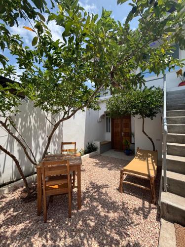 two chairs and a table under a tree at Samia House in Jambiani
