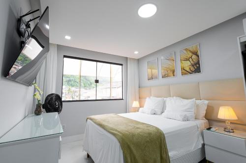Un dormitorio con una cama blanca y una ventana. en Studio Praia do jardim 1 205A, en Angra dos Reis