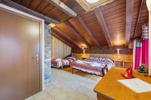 a room with two beds and a table at Arthemisia - Rhêmes-Notre-Dame in Rhêmes-Notre-Dame