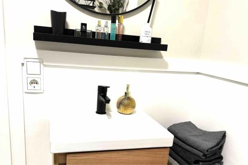 a bathroom with a vanity with a mirror and a shelf at Wohlfühlapartment in Wals vor den Toren Salzburg in Wals