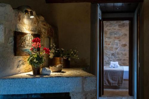 a room with a table with flowers on it at Tzokeika Traditional Settlement in Riglia