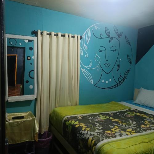 a bedroom with a mural of a woman on the wall at Kristian Homestay in Bajawa