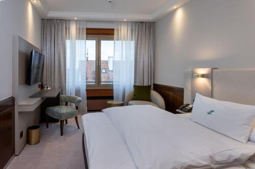 a hotel room with a bed and a desk and a window at Insel-Hotel Heilbronn in Heilbronn