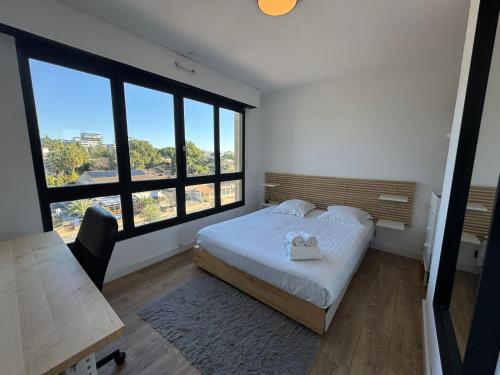 une chambre avec un lit et une grande fenêtre dans l'établissement Bellevue - Premiere conciergerie, à Montpellier