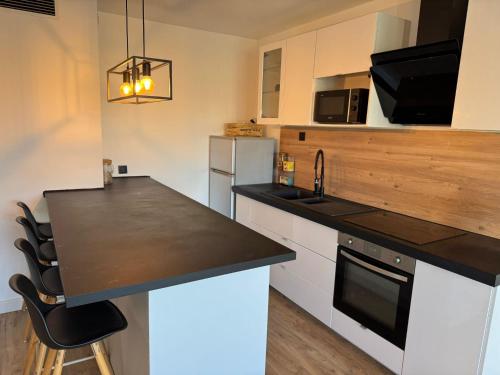 Il comprend une cuisine équipée d'un comptoir noir et d'un réfrigérateur. dans l'établissement Bellevue - Premiere conciergerie, à Montpellier