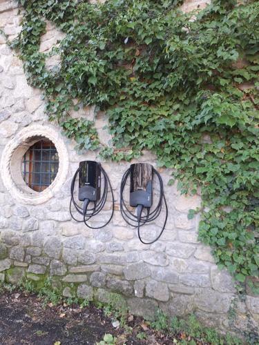 two lights on a stone wall with ivy at Chiesa Ignano 1778 in Marzabotto