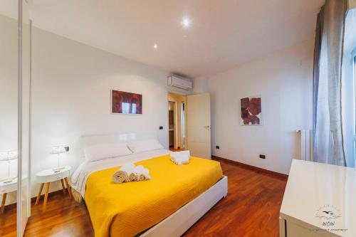 a bedroom with a yellow bed with a yellow blanket at Wow Waterfront Apartment in Bari