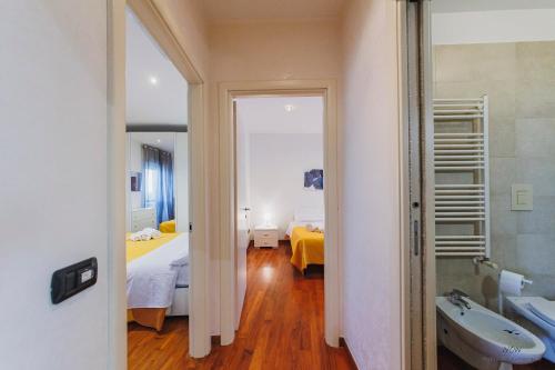 a bathroom with a sink and a room with two beds at Wow Waterfront Apartment in Bari