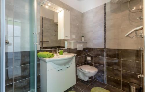 La salle de bains est pourvue de toilettes, d'un lavabo et d'une douche. dans l'établissement Apartments Kike, à Kaštela