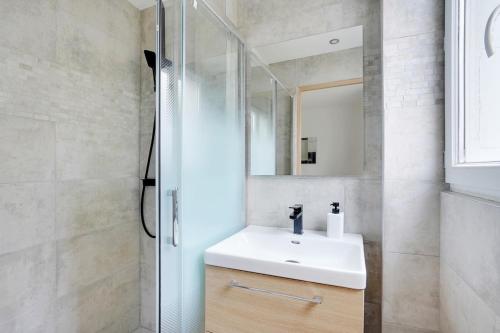une salle de bain avec un lavabo blanc et une douche dans l'établissement Apartment Suite 33 Au Portes de PAris, à Aubervilliers