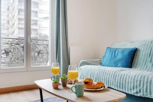 - un salon avec une table basse et deux verres de jus d'orange dans l'établissement Apartment Suite 33 Au Portes de PAris, à Aubervilliers
