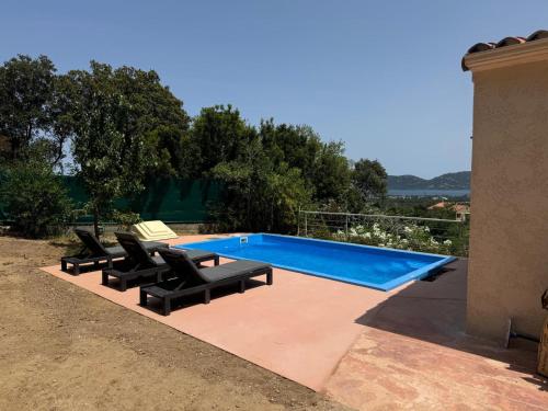 une piscine avec des chaises longues à côté d'une maison dans l'établissement Villa vue mer et montagnes 9 pers, à Porto-Vecchio