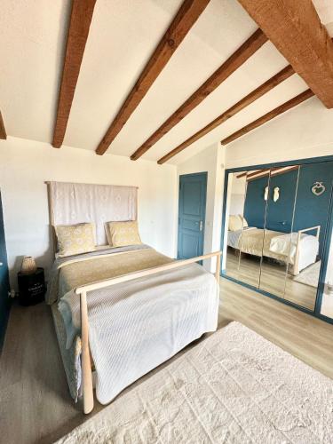 une chambre avec un grand lit et un miroir dans l'établissement Villa vue mer et montagnes 9 pers, à Porto-Vecchio