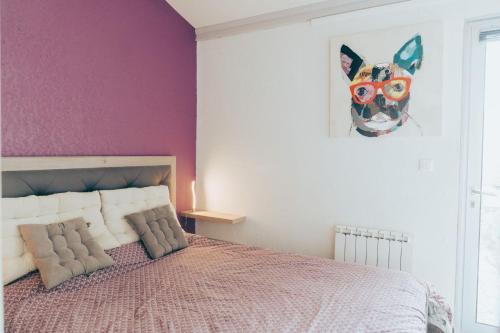 une chambre avec un lit avec un mur violet dans l'établissement Naturiste Cap d'Agde Villa Héliovillage 39, au Cap d'Agde