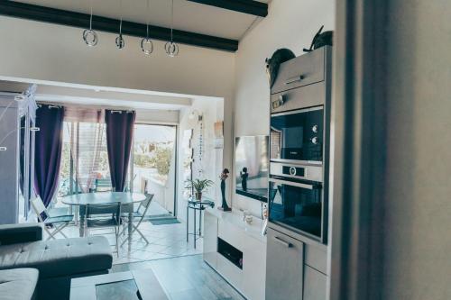 une cuisine et un salon avec un canapé et une table dans l'établissement Naturiste Cap d'Agde Villa Héliovillage 39, au Cap d'Agde